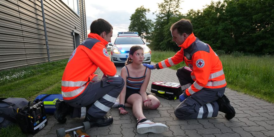 Foto: Eine junge Dame ist gestürzt, Die DRK First Responder versorgen die Verunfallte.