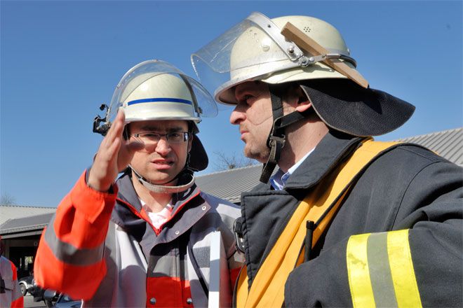 Foto: Während einer Helferübung zum Thema Brandanschlag koordiniert sich die DRK-Bereitschaftsleitung mit dem Leiter der Feuerwehr.